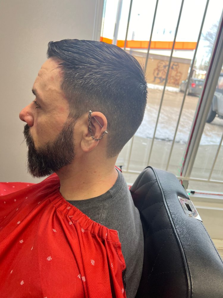 Slicked-back cut with a fade and full beard